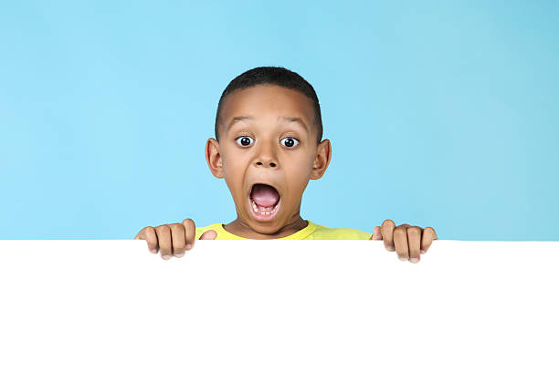 istock Cute american boy with blank board on blue background 2204506892