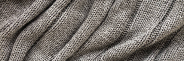 istock Dark gray wavy soft knitted fabric background. Closeup. Wide banner. Top down view. 2204508046