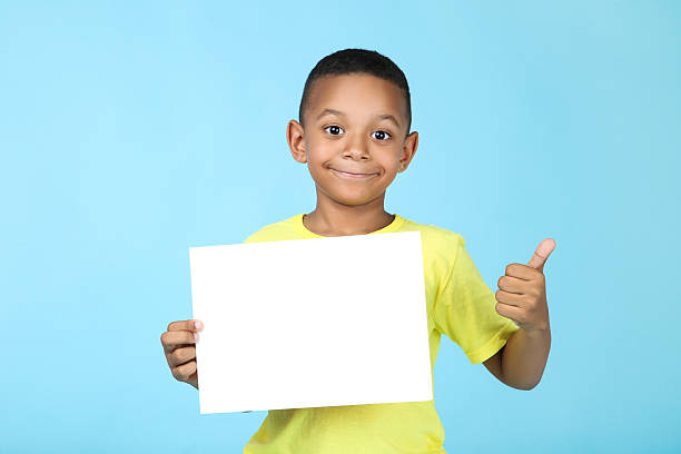 istock Cute american boy with blank board on blue background 2204509233