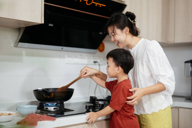 istock Asian toddler boy helping his mom preparing lunch 2204510856