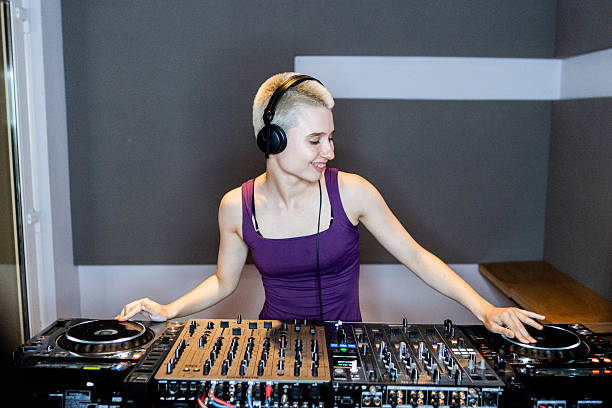 istock Young DJ woman using sound mixer at studio 2204511063