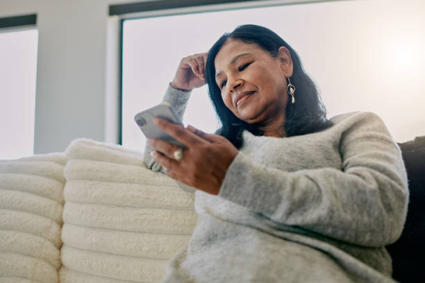 istock Mature woman spending leisure time using mobile phone at home 2204512405
