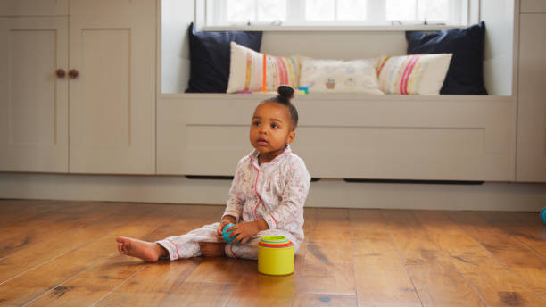 istock Female Toddler At Home Playing With Stacking Plastic Toy 2204512746
