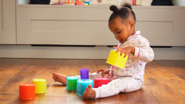 istock Female Toddler At Home Playing With Stacking Plastic Toy 2204512796