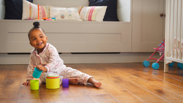 istock Female Toddler At Home Playing With Stacking Plastic Toy 2204513090
