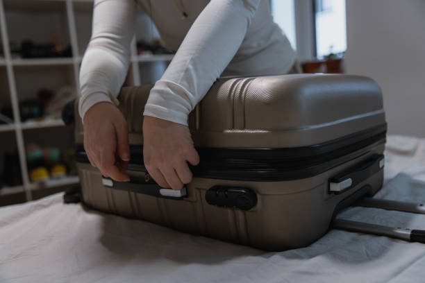 istock Closing a Packed Suitcase Before Travel - Preparing for road trip 2204514731