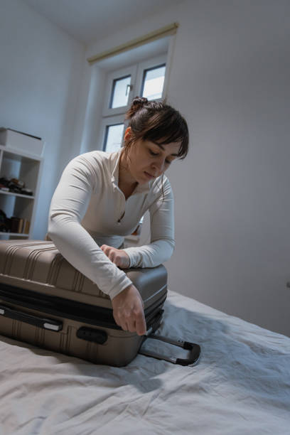istock Closing a Packed Suitcase Before Travel - Preparing for road trip 2204514735