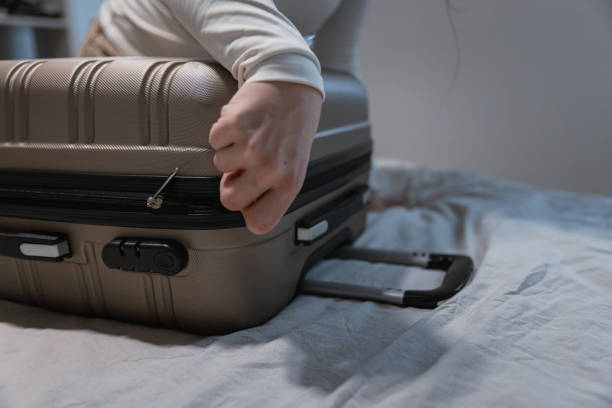 istock Closing a Packed Suitcase Before Travel - Preparing for road trip 2204514785