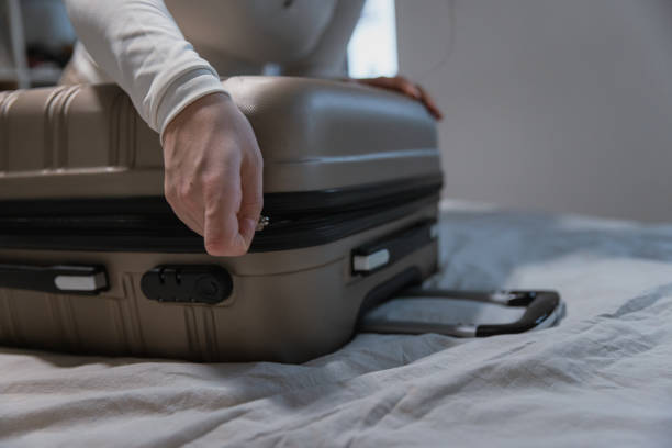 istock Closing a Packed Suitcase Before Travel - Preparing for road trip 2204515133
