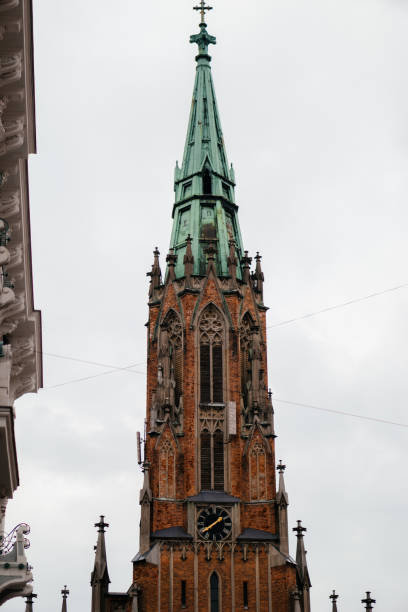 istock A stunning Gothic church spire with intricate architectural details, aged brickwork, and a patina-covered roof, set against a moody overcast sky 2204515951