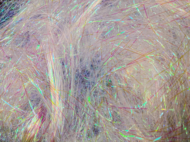 istock Close-up image of textured surface with fur or similar material central, vibrant colored fibers purple, blue, green, contrasting against white background, abstract 2204516314