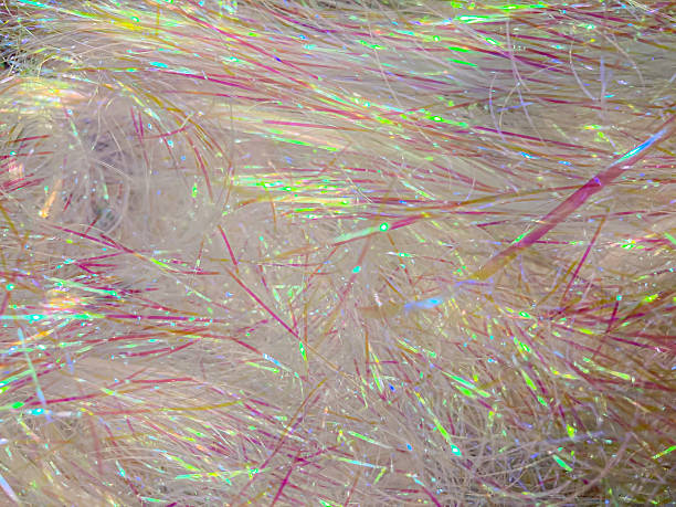 istock Close-up image of shimmering, light pink and yellow shredded material in abstract pattern, emphasizing texture and color 2204516316