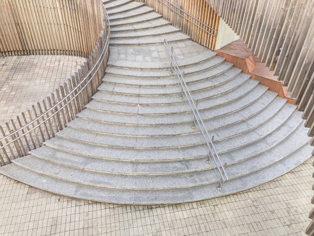 Image of a spiral staircase made from concrete or stone, with a cylindrical inner core for structural support The stairs ascend in a continuous looping pattern, and the photo captures the full spira