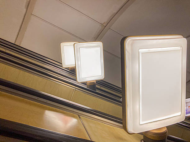 istock A still escalator, bathed in artificial light, displays vibrant ads featuring a baby and a dog against monochrome surroundings The setting suggests a subway station, with Russian words hinting at it 2204516715