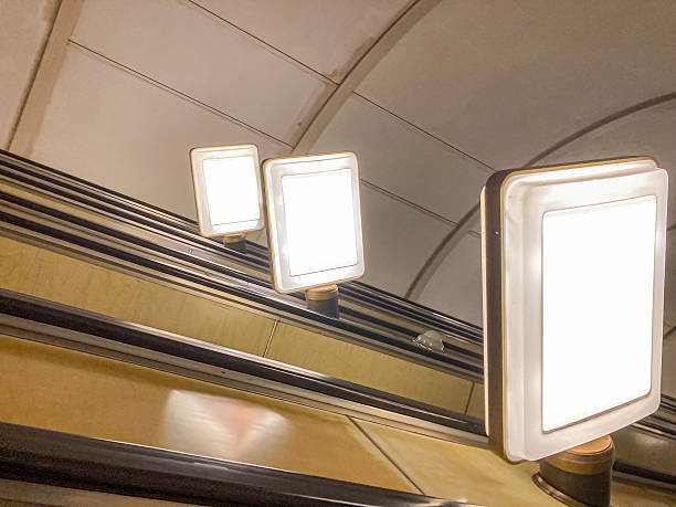 A candid shot of an escalator with two ascending steps, each step displaying advertisements or information The photo emphasizes the upward perspective and features additional advertising above the h