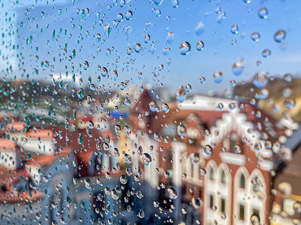 istock A tranquil urban street view, captured through a window during light rain with blurred buildings and soft focus The scene shows an amalgamation of architectural styles, including a traditional Europ 2204516746