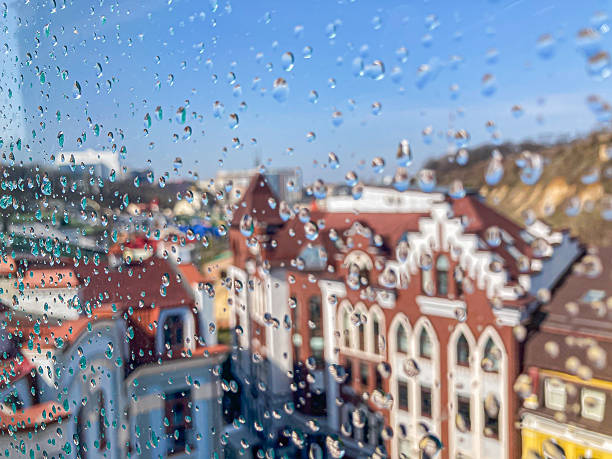 istock An older European cityscape viewed through a rain-soaked window, showcasing multi-storied buildings with bay windows and ornate detailing in a narrow street layout 2204516749