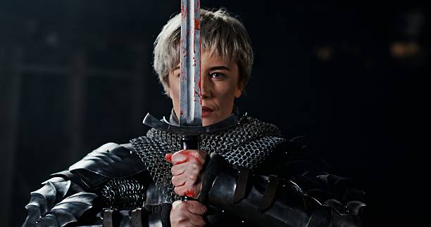 istock A valiant warrior in shining armor raises his sword high, ready for fierce battle 2204516964