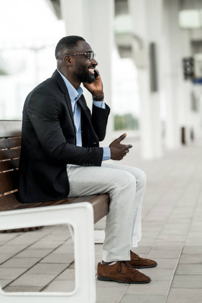 istock Happy black businessman waiting for train on railway station. 2204518768