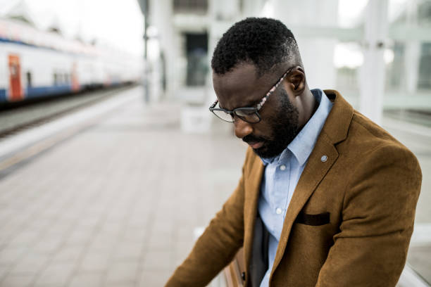istock Depressed black businessman waiting on train station 2204520222