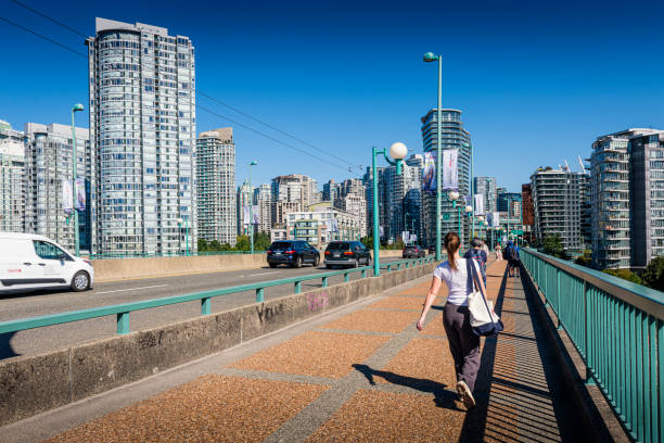 Vancouver, Canada - August 18, 2023: Pedestrians walking over the modern Granville Bridge in Vancouver in Canada.