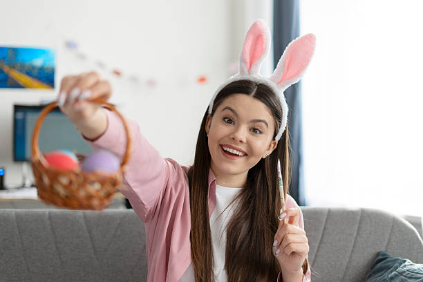 istock Young woman painting easter eggs at home 2204520913