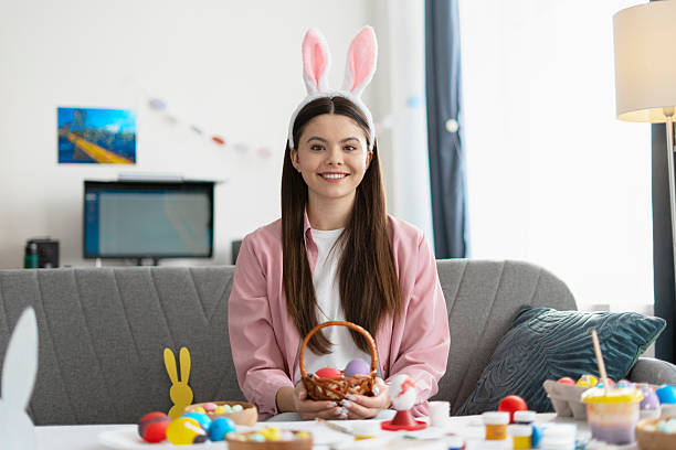 istock Young woman painting easter eggs at home 2204520929