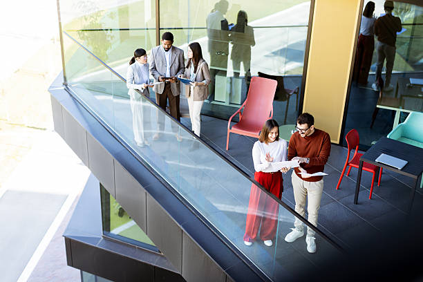 istock Colleagues engage in a productive discussion on a modern office balcony during a sunny afternoon 2204521249