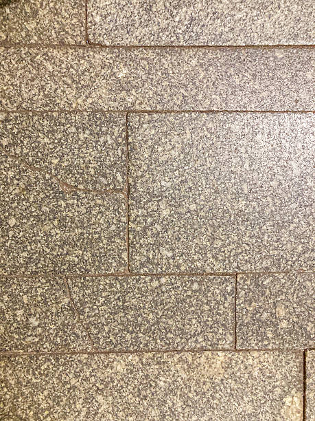 Close-up view of textured stone or similar material, with irregular mosaic pattern, possible multiple layerssurfaces, and uneven lighting
