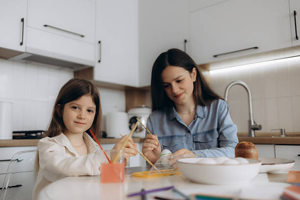 istock Mother and Daughter Painting Eggs Together in a Bright Kitchen 2204522507