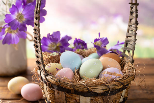 istock Easter eggs and flowers in a basket with springtime background 2204525728