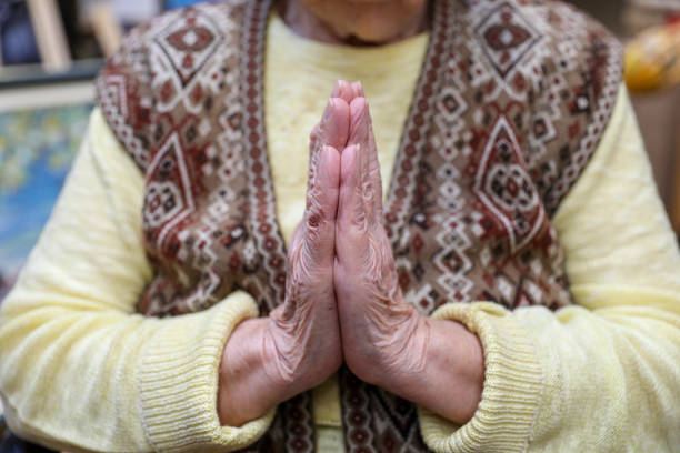 An old woman praying. Close-up. Nursing home