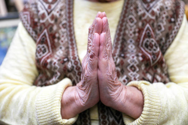 An old woman praying. Close-up. Nursing home