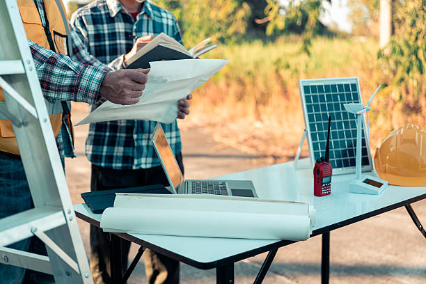istock Cropped shot of architect holding digital tablet while working on new real estate project, sitting at desk with engineering tools and architectural model house, building and construction, close up. 2204532228