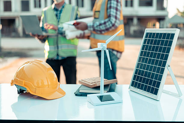 istock Cropped shot of architect holding digital tablet while working on new real estate project, sitting at desk with engineering tools and architectural model house, building and construction, close up. 2204532257