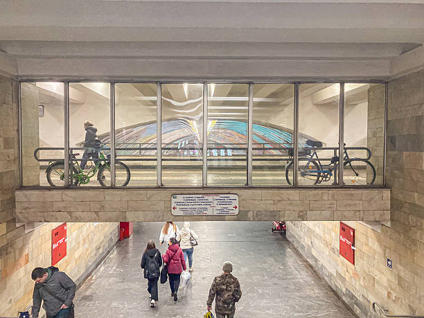 A busy indoor subway station with natural light, bicycles, commuters, dynamism, polished floor, white and brown walls Kyiv, Ukraine, 03-15-2024