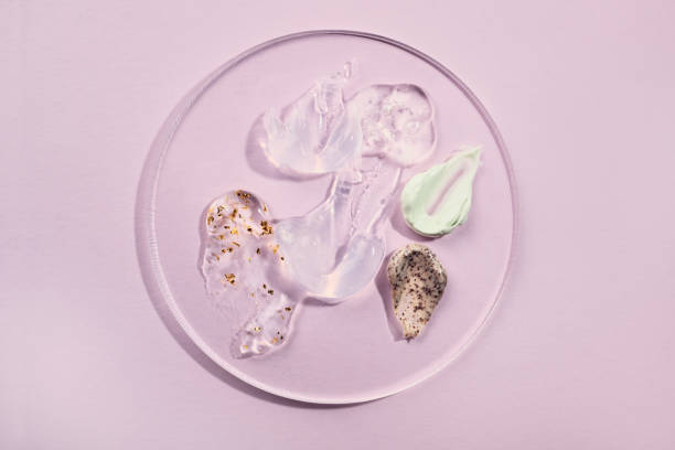 istock Assorted skincare gels and creams on clear petri dish. Multifunctional cosmetic samples on pink background 2204535218