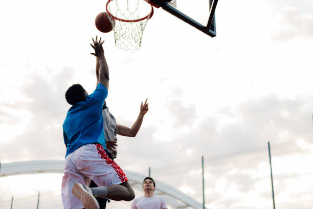 istock Basketball player shooting ball during game with teammates 2204537016
