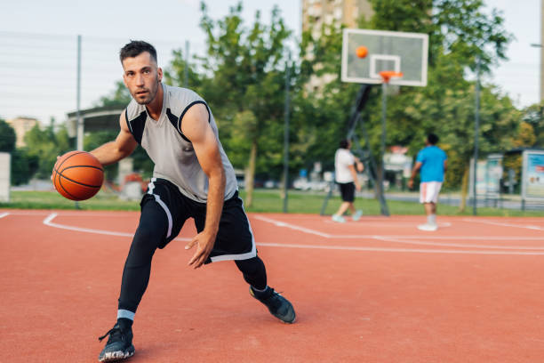 istock Basketball player dribbling ball on court during a match 2204537026