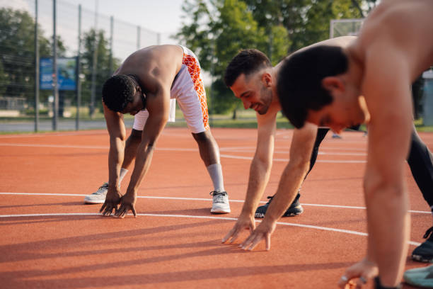 istock Athletes stretching together before training outdoors on a court 2204537044