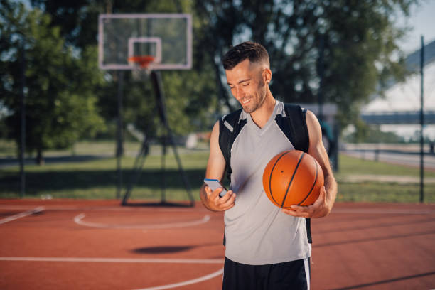 istock Basketball player using smartphone on outdoor court 2204537065