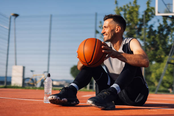 istock Basketball player relaxing after training outdoors on court 2204537068