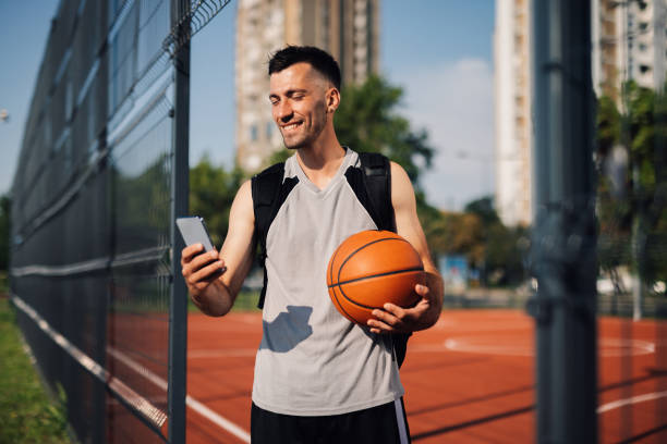 istock Basketball player using smartphone on outdoor court 2204537084