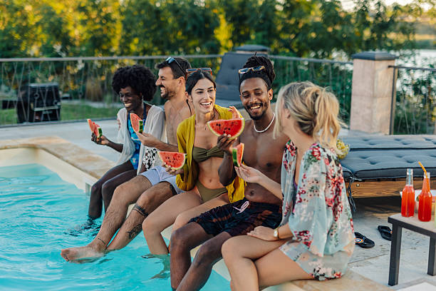 istock Friends eating watermelon and relaxing by the poolside 2204539446