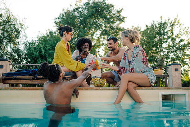 istock Friends toasting colorful drinks at a luxurious pool party 2204539507