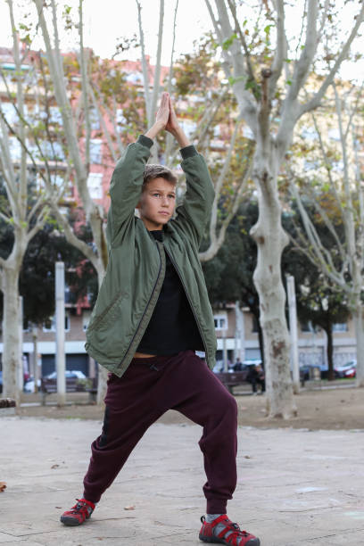 istock Handsome teenager doing exercises outdoors 2204540430