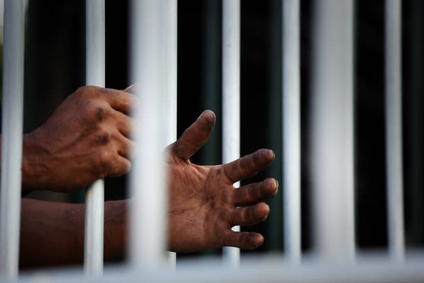 istock Hands Reaching Through Prison Bars Symbolizing Incarceration and Despair 2204540567