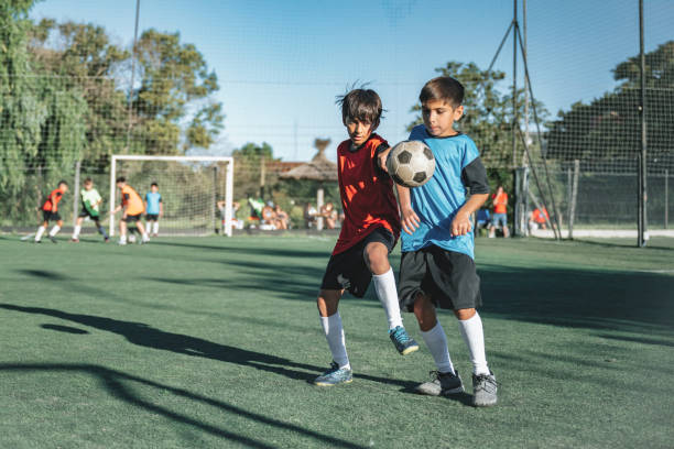 istock two boys fighting for soccer ball in match 2204545578