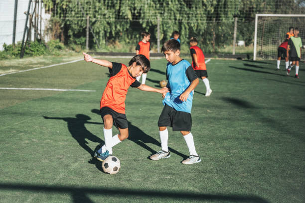 istock two boys fighting for soccer ball in match 2204545615