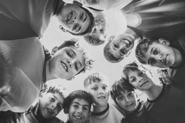 boy soccer team standing in circle and and looking down to camera
